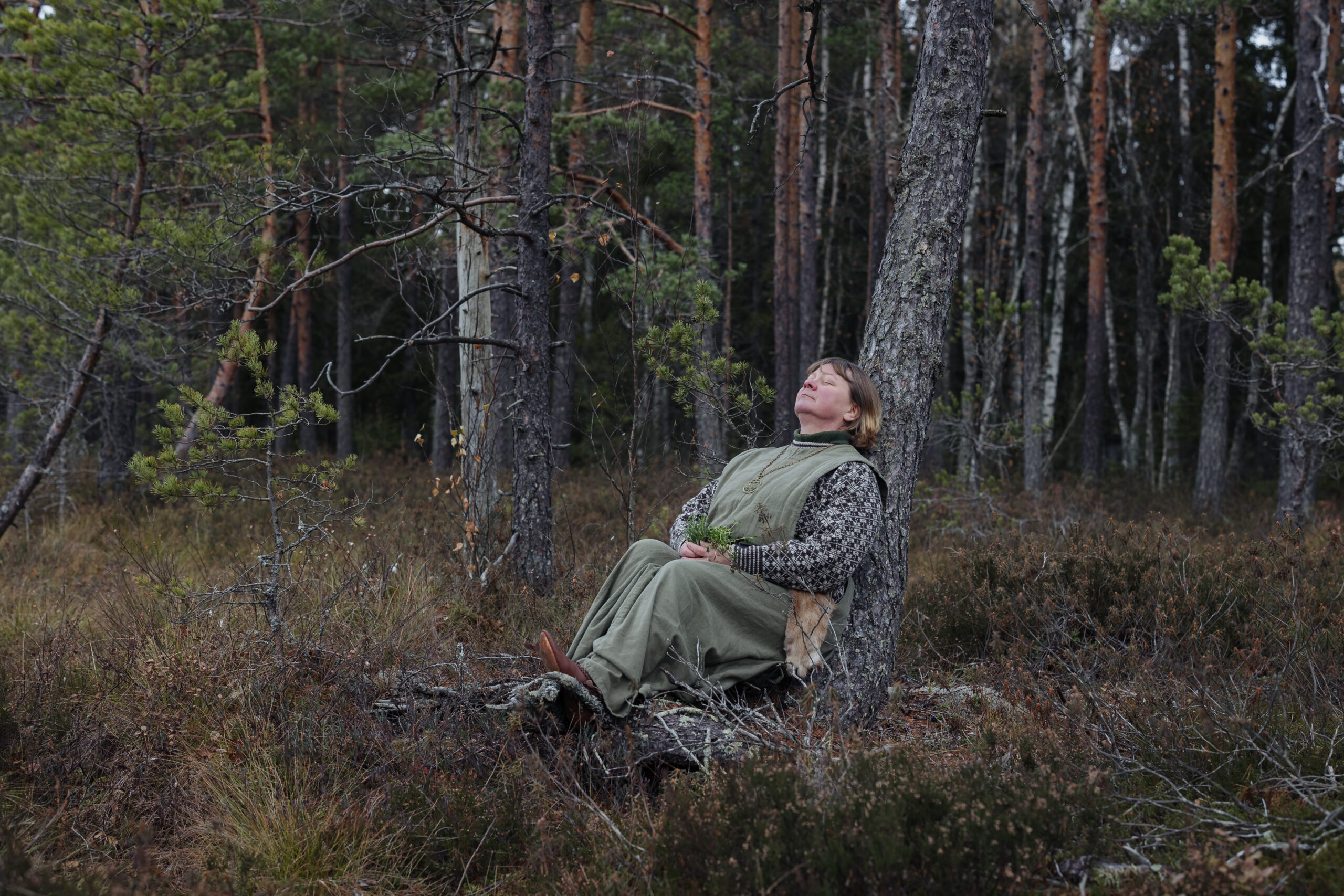 Luontovalmentaja nojaa puunrunkoon Torronsuolla.